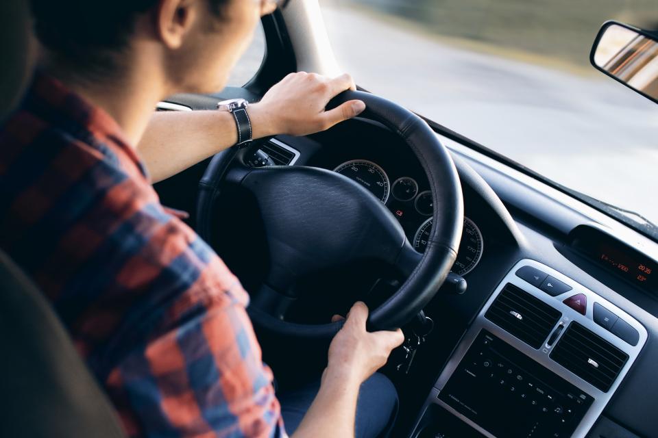 A driver with both hands on the steering wheel
