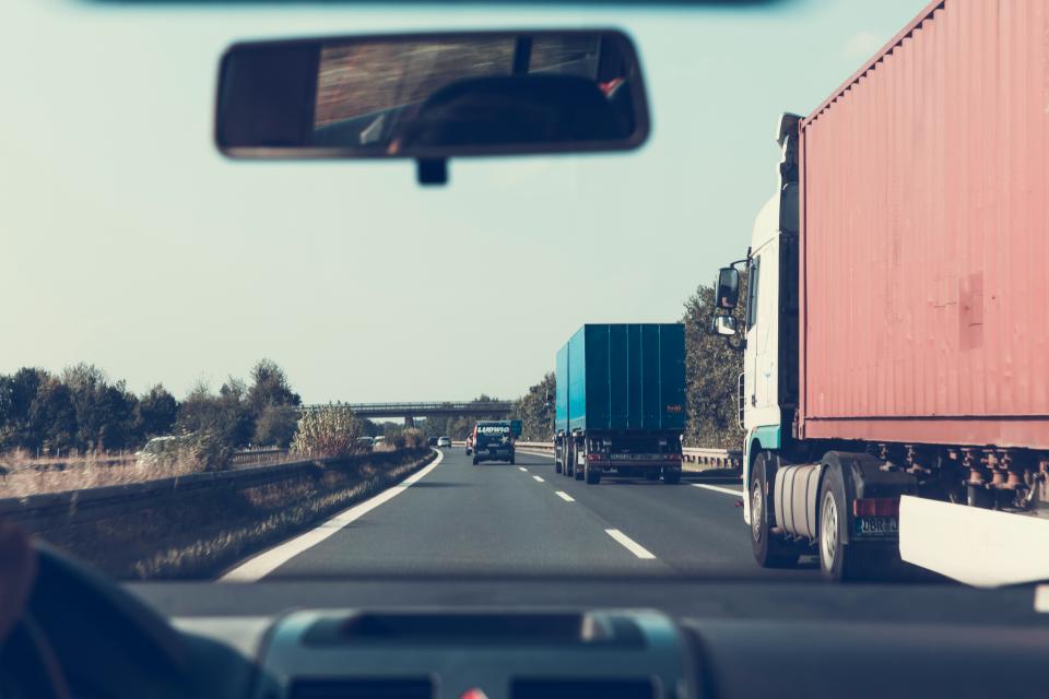 Transport trucks on a highway seen from a vehicle dashboard